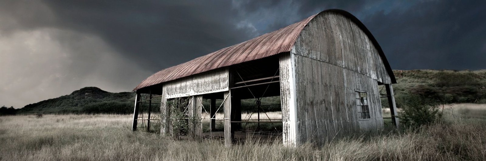 An abandoned barn under a stormy sky, from the Abandoned Places series by Martin Osner