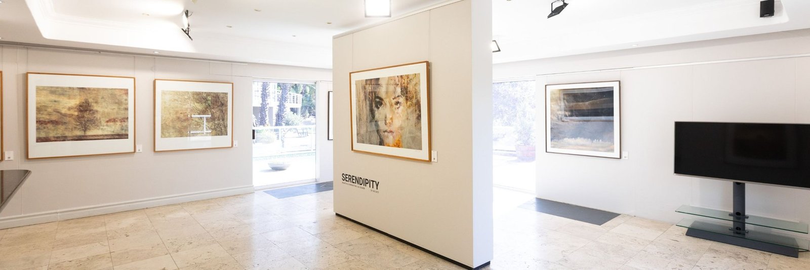 Framed paintings and photographs on the walls of Osner Gallery in Hout Bay