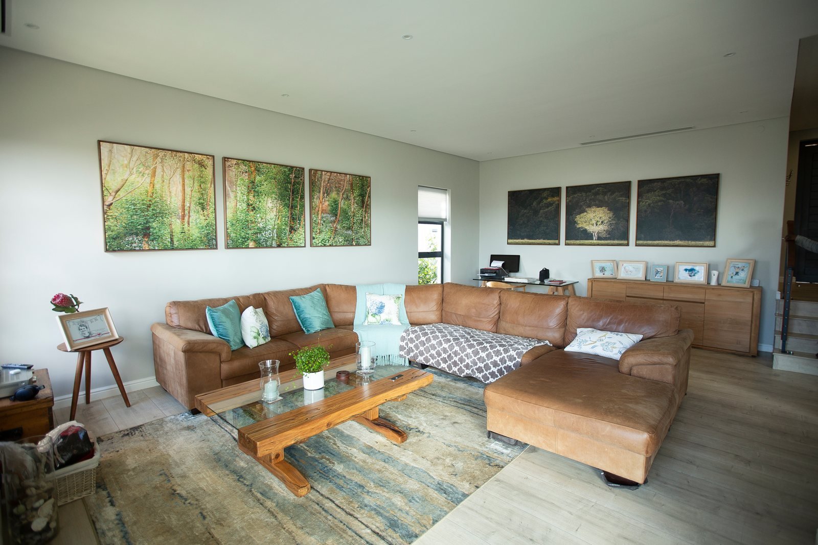 The same lounge with two sets of three large artworks hung on its walls
