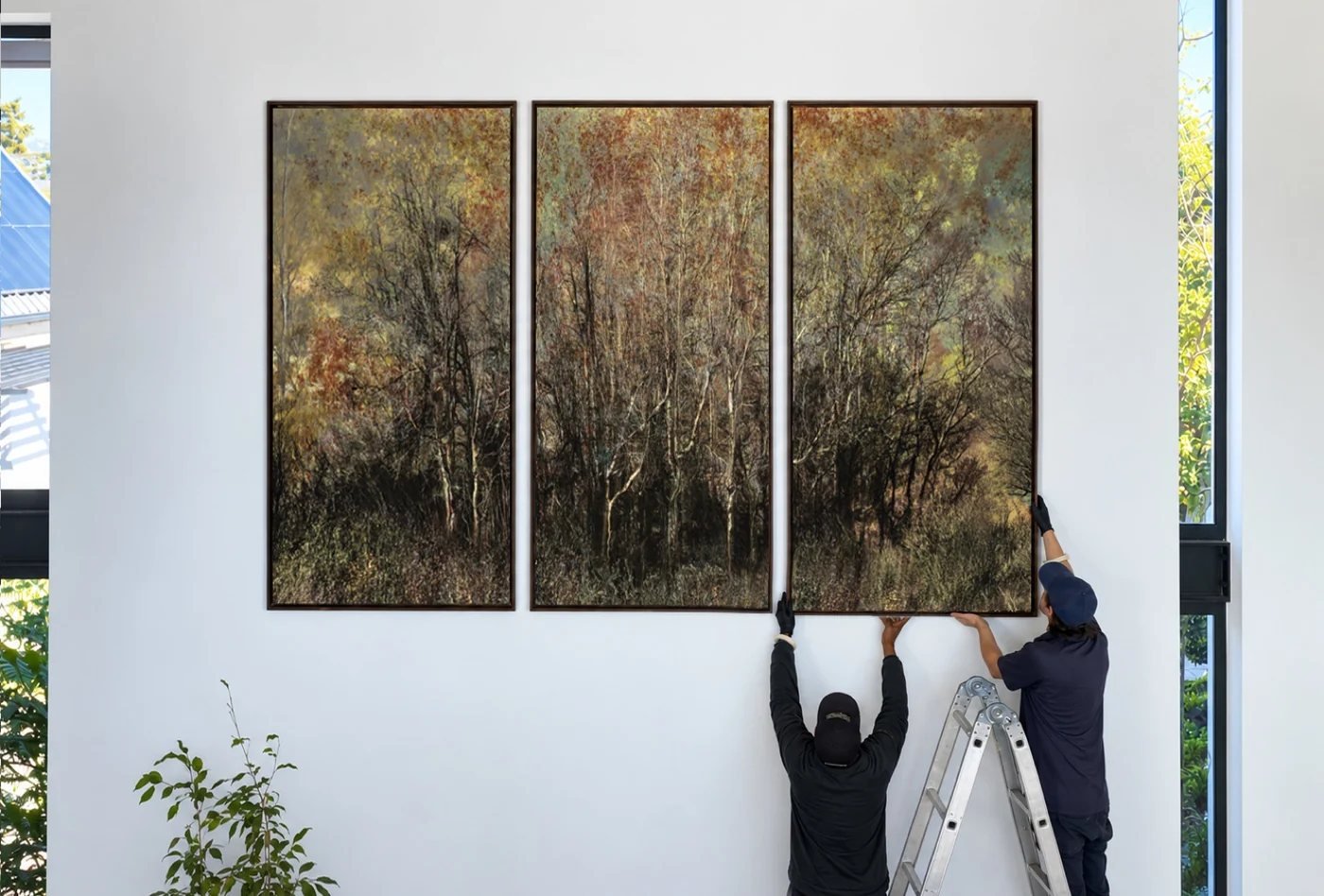 Our team installing a large commissioned triptych in a home at Val de Vie